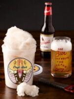 An opened tub of IPA Beer Cotton Candy, beer bottle, and glass filled with beer.